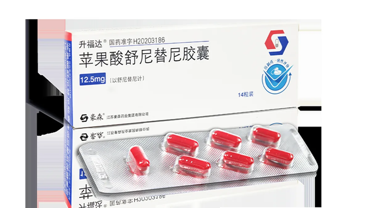 患者手持舒尼替尼50mg处方和药盒,背景是医院药房窗口